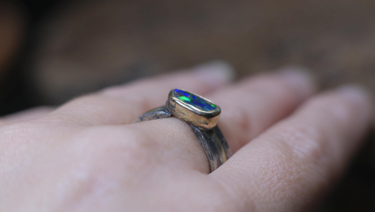 Dazzling boulder opal set in 9ct gold and on a unique textured sterling silver band with 9 ct gold detail