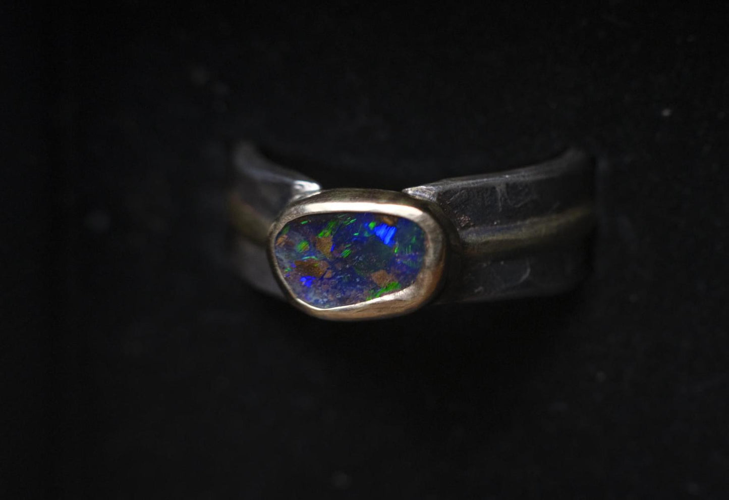Dazzling boulder opal set in 9ct gold and on a unique textured sterling silver band with 9 ct gold detail