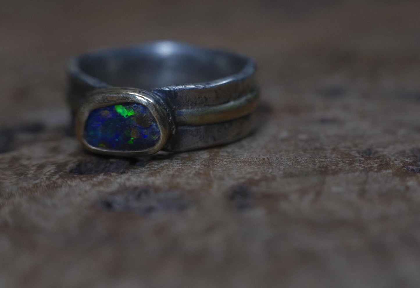 Dazzling boulder opal set in 9ct gold and on a unique textured sterling silver band with 9 ct gold detail