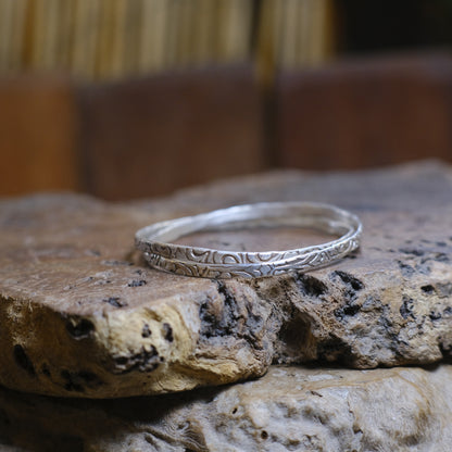 Pair of handmade interlocking sterling silver bangles with textured arabesque pattern