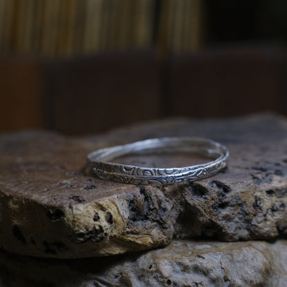 Pair of handmade interlocking sterling silver bangles with textured arabesque pattern