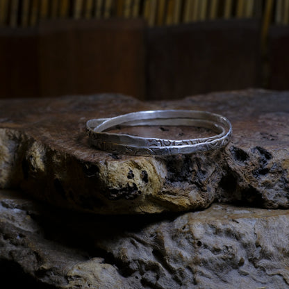 Pair of handmade interlocking sterling silver bangles with textured arabesque pattern