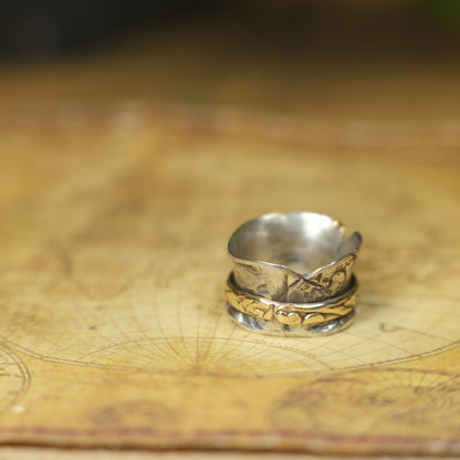 Handmade 9ct yellow gold spinner ring on a wide textured oxidised sterling silver band