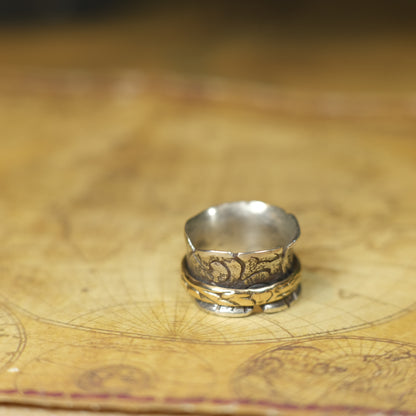 Handmade 9ct yellow gold spinner ring on a wide textured oxidised sterling silver band