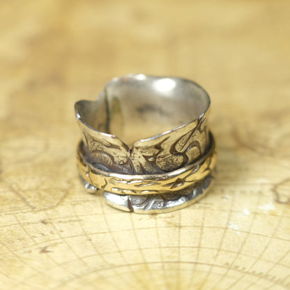 Handmade 9ct yellow gold spinner ring on a wide textured oxidised sterling silver band