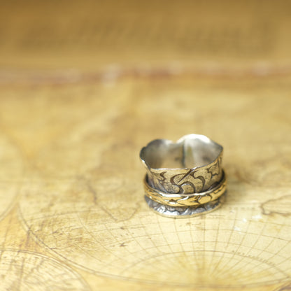 Handmade 9ct yellow gold spinner ring on a wide textured oxidised sterling silver band