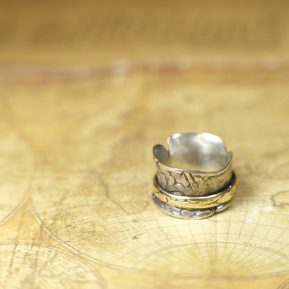 Handmade 9ct yellow gold spinner ring on a wide textured oxidised sterling silver band