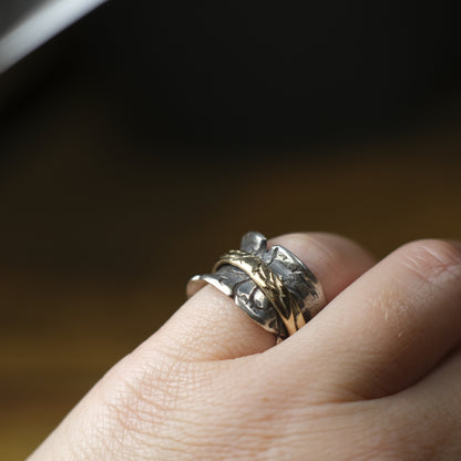 Handmade 9ct yellow gold spinner ring on a wide textured oxidised sterling silver band