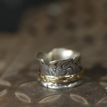 Handmade 9ct yellow gold spinner ring on a wide textured oxidised sterling silver band