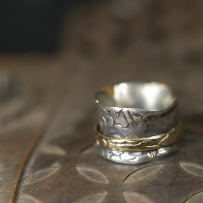Handmade 9ct yellow gold spinner ring on a wide textured oxidised sterling silver band