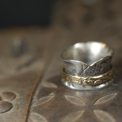 Handmade 9ct yellow gold spinner ring on a wide textured oxidised sterling silver band
