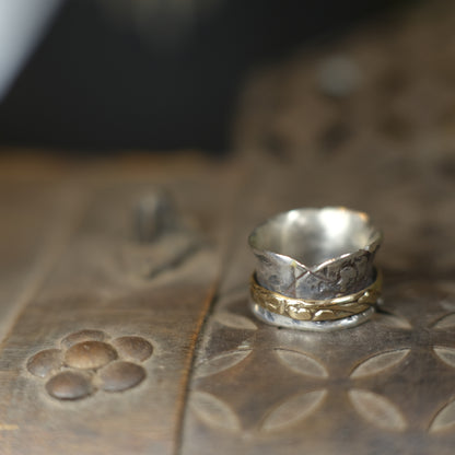 Handmade 9ct yellow gold spinner ring on a wide textured oxidised sterling silver band