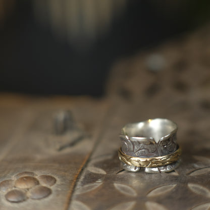 Handmade 9ct yellow gold spinner ring on a wide textured oxidised sterling silver band