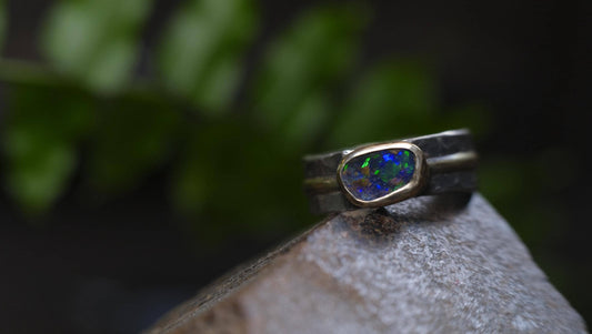 Dazzling boulder opal set in 9ct gold and on a unique textured sterling silver band with 9 ct gold detail