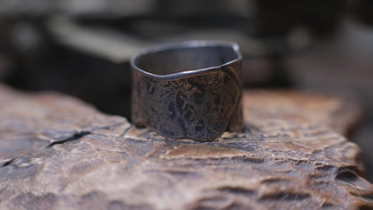 Rugged wide-band pirate-inspired sterling silver ring with oxidised hammered texture