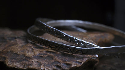 Pair of handmade interlocking sterling silver bangles with textured arabesque pattern