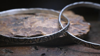 Pair of handmade interlocking sterling silver bangles with textured arabesque pattern