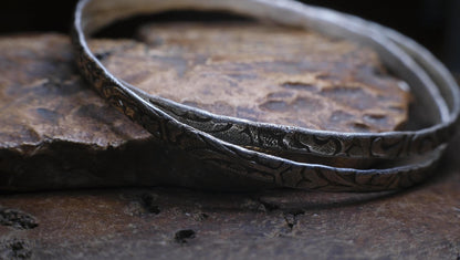 Pair of handmade interlocking sterling silver bangles with textured arabesque pattern