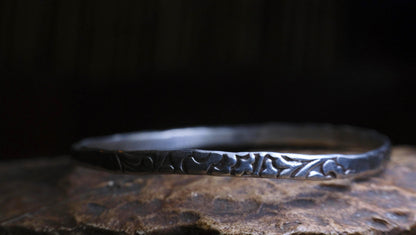 Handmade sterling silver bangle with textured Victorian-inspired arabesque pattern