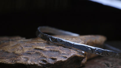 Handmade sterling silver bangle with textured Victorian-inspired arabesque pattern