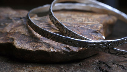 Pair of handmade interlocking sterling silver bangles with textured arabesque pattern