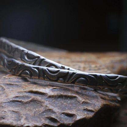 Pair of handmade interlocking sterling silver bangles with textured arabesque pattern