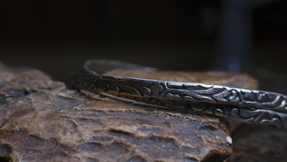 Pair of handmade interlocking sterling silver bangles with textured arabesque pattern
