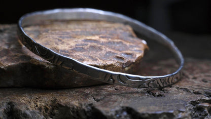 Handmade sterling silver bangle with textured Victorian-inspired arabesque pattern
