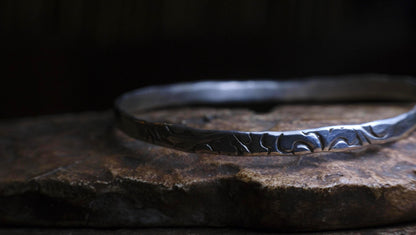 Handmade sterling silver bangle with textured Victorian-inspired arabesque pattern