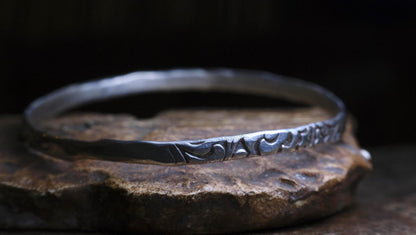 Handmade sterling silver bangle with textured Victorian-inspired arabesque pattern