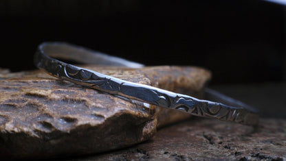 Handmade sterling silver bangle with textured Victorian-inspired arabesque pattern