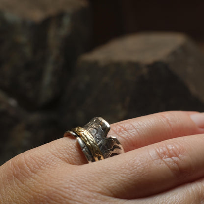 Handmade 9ct yellow gold spinner ring on a wide textured oxidised sterling silver band